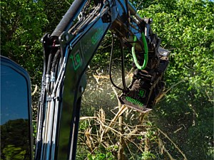 Forestry mulcher on an excavator being used to mulch a tree in Pennsburg