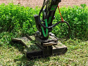 Close up picture of brush mower being used on the side of a driveway