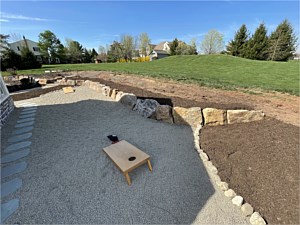 Boulder wall with corn hole playing area